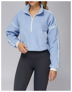 Detail of light blue fleece pullover with high collar and cozy grainy fabric texture