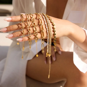 Vue détaillée de bracelets superposés en acier inoxydable doré 18K avec breloques étoiles