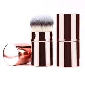 Portable retractable makeup brush in rose gold with soft synthetic bristles and cap