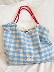 Blue and white plaid tote bag with red drawstring rope handles and embroidered label