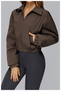 Detail of dark brown zip-up jacket featuring elastic cuffs and turn-down collar