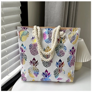 Detail of canvas tote bag with metallic pineapple print and natural rope handles