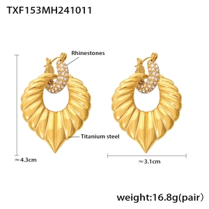 Detail view of leaf-shaped titanium steel earrings with rhinestones on a white background