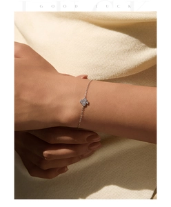 Macro detail of S925 sterling silver four-leaf clover bracelet with paved moissanite stones