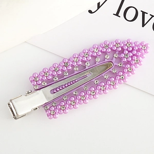 Purple flower hair clip with sparkling rhinestones and pearls on a sleek metal base