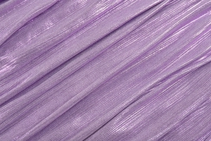 Macro shot of purple pleated fabric with metallic glitter yarn and fine texture