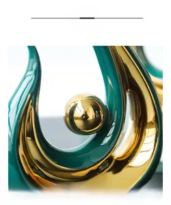 Detailed macro view of green ceramic glaze and polished gold plated sphere sculpture