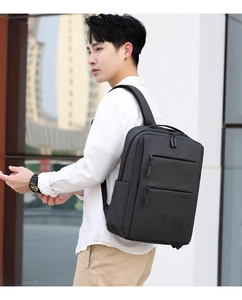 Side view of a black business laptop backpack worn by a model against a modern building