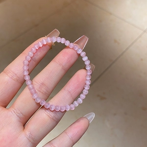 Close-up of pink cat eye stone beaded bracelet showing natural shimmer and elastic cord