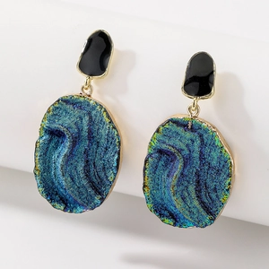 Detailed close-up of vintage oval enamel earrings with blue-green iridescent mineral texture