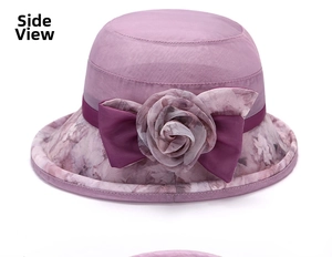 Détail d'un chapeau de soleil à fleurs mauves avec fleur en tissu 3D et ruban élégant