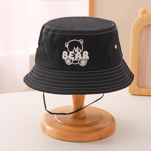 Detail of bear embroidery and white stitching on black cotton bucket hat with chin strap