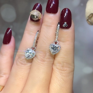Elegant heart-shaped zircon drop earrings with halo pave setting shown in hand