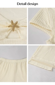 Detail design of cream textured knit set featuring a gold starfish brooch on the top