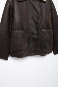 Close-up of vintage brown faux leather jacket showing shearling lining and large pockets