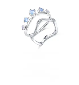 Detailed macro view of S925 sterling silver crown and wavy rings with blue gradient gems
