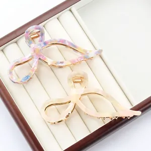 Elegant bow hair claw clips set in marble pattern and pearly white acetate finish