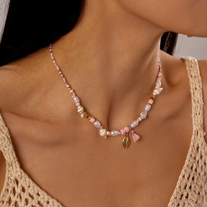 Detail of beach style necklace with pearls shells and tassels on woman neck