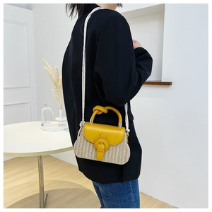 Detail of yellow leather and woven straw crossbody bag with white rope shoulder strap