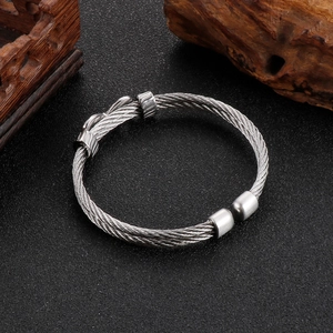 Detailed view of silver steel cable texture on a punk-style infinity cuff bracelet