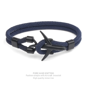 Detail of blue hand-knitted Milan rope bracelet with a black aircraft charm