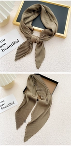 Detail of khaki pleated square scarf showing high-density vertical pleats and soft texture