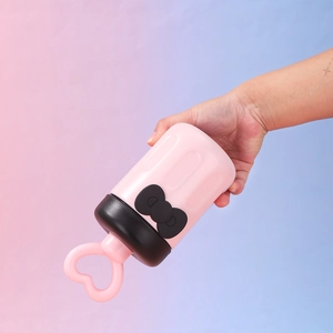 Close-up of pink ice cream shaped vacuum cup with black bow and heart handle detail
