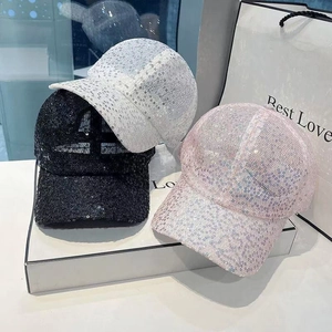 Close-up of sparkling sequin baseball caps in black, white, and pink fashion colors