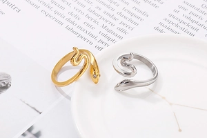 Detailopname van slangvormige ringen in goud en zilver met glanzende strass-ogen