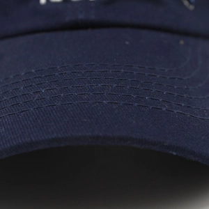 Detail shot of navy cotton baseball cap brim showing parallel reinforced stitching