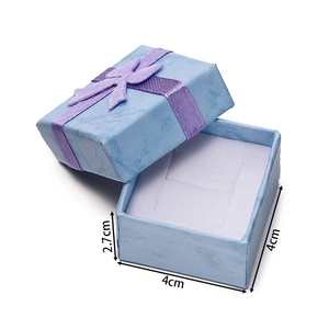 Detail view of 4x4x2.7cm blue jewelry gift box with textured paper and purple bow