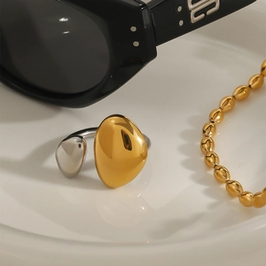 Detailed close-up of two-tone stainless steel teardrop ring on a white plate