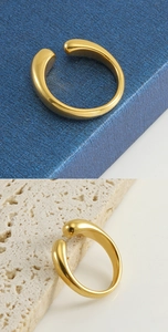 Vues détaillées d'une bague ouverte dorée sur des fonds contrastés bleus et pierre
