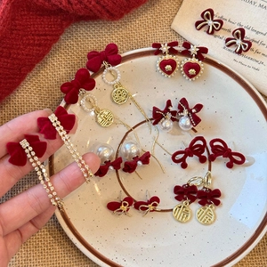 Red bow stud earrings with silver needles and festive flocking for winter season