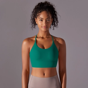Front view of green halter yoga sports bra with wide band and skinny straps on model