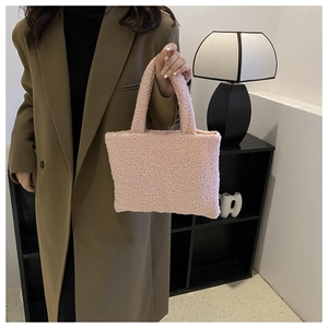 Detail shot of the soft pink plush texture and sturdy handles on the luxury furry handbag