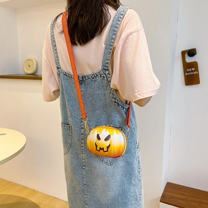 Detail of the pumpkin-shaped crossbody bag worn by a model in a modern interior setting