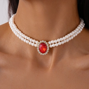 Detailed view of luxury double-layer pearl choker with red oval gemstone and rhinestones