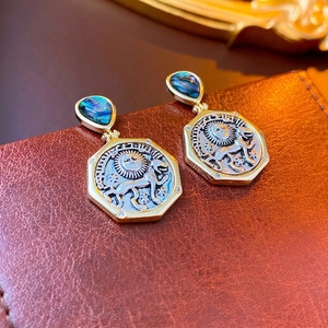 Vintage gold drop earrings with abalone shell inlay and sun lion coin relief on leather