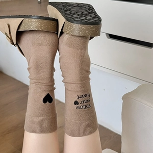 Detailed embroidery of black heart and Follow Your Heart text on brown cotton socks