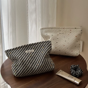 Retro woven polka dot and striped fabric makeup bags on a wooden table setup