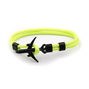 Close-up of neon green paracord bracelet featuring a black airplane charm and hardware