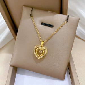 Detailed close-up of golden heart-shaped necklace with shimmering crystals on display