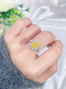 Macro shot of s925 silver ring with cushion-cut yellow carbon diamond on silk background
