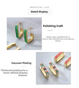 Macro shot of U-shaped gold plated earrings with emerald and rainbow rectangular stones