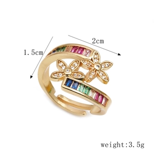 Adjustable gold flower ring with rainbow zircons and pavé crystals on white background