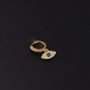 Pendiente de aro ojo turco dorado con circonitas rosas y piedra azul sobre fondo negro