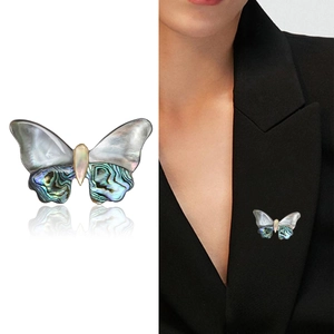 Elegant butterfly brooch with iridescent abalone shell wings and polished metal body