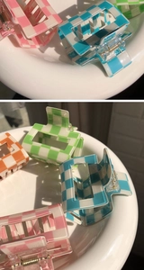Detailed view of colorful acrylic checkered claw clips in pink, blue, green and orange