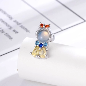 Whimsical silver mermaid ear stud with colorful cubic zirconia on a white display stand